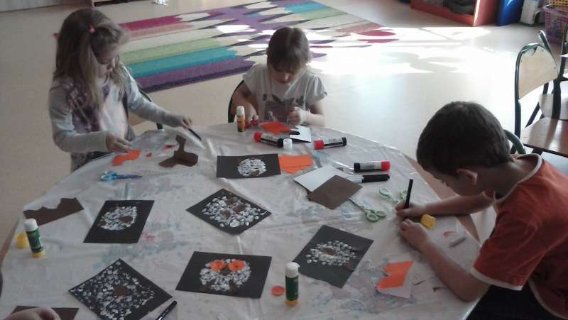 Dzieci w przedszkolu sklejają ozdoby